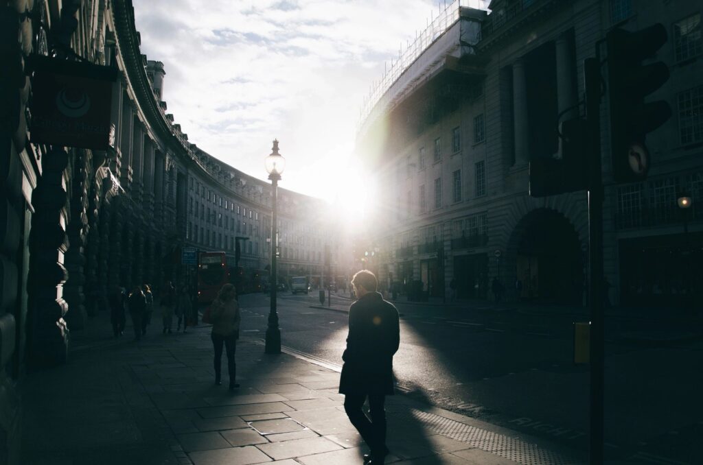 man in the city with the sun shining in the background is full of happiness from using practical travel tips 
